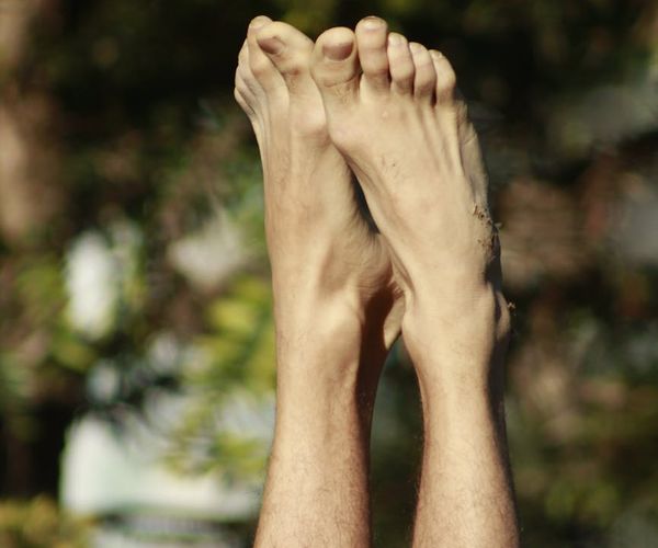 Person in a calm yoga pose outdoors with a serene natural background.